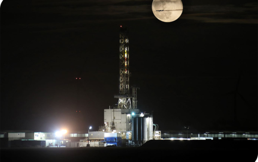 Afbeelding van een boorinstallatie in de nacht/in het donker