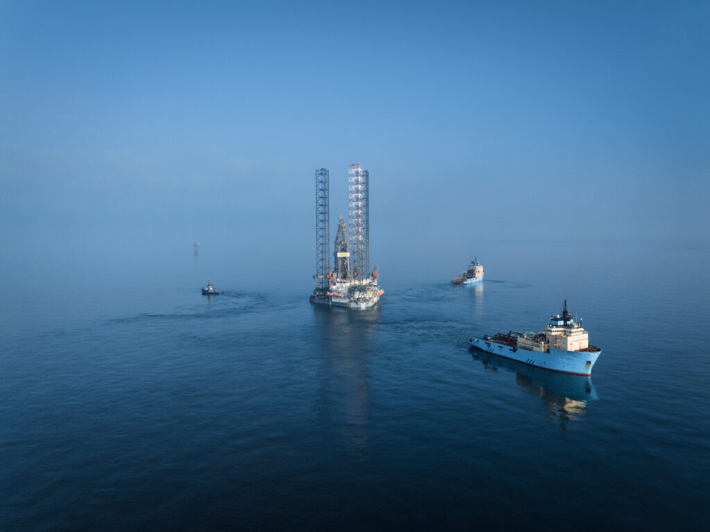 Afbeelding van een platform op zee waar boten af- en aanvaren